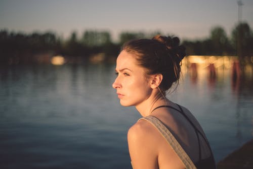woman looking out into the distance facing water