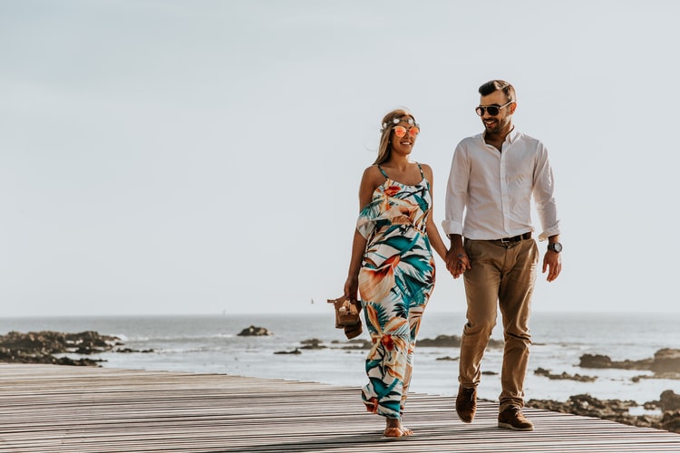 couple walking holding hands on boardwalk