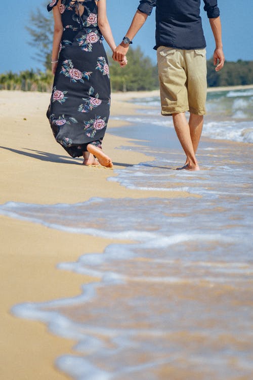 couple walking on beach holding hands